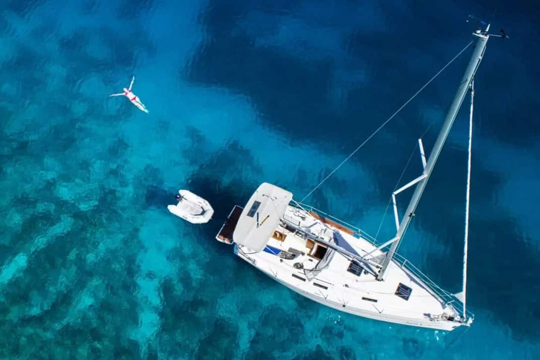 Woman swimming near boat | Sebastus Sailing