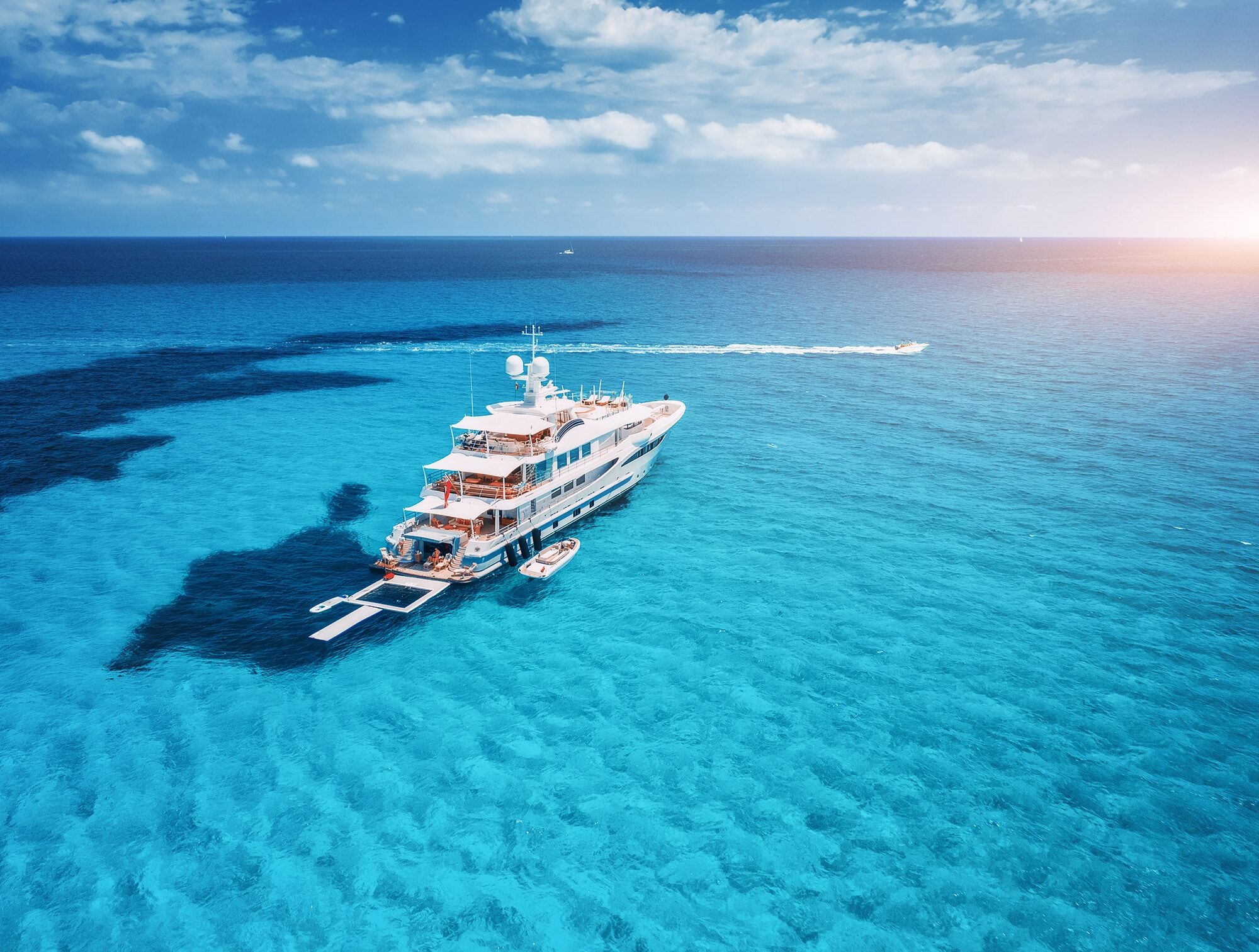 Luxury yacht charter on the ocean with a small boat in front