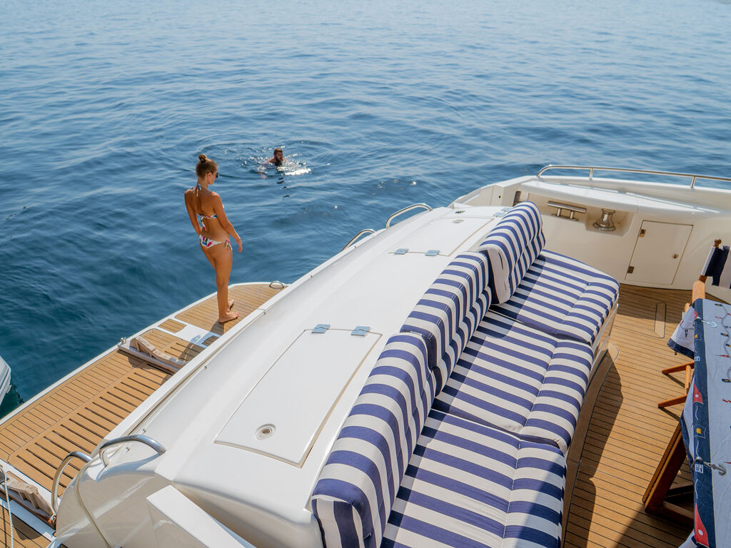 Woman on boat deck and person swimming