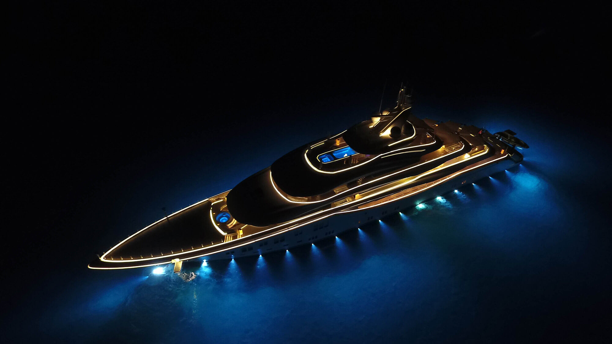 luxury motor yacht with deck lights on in the night