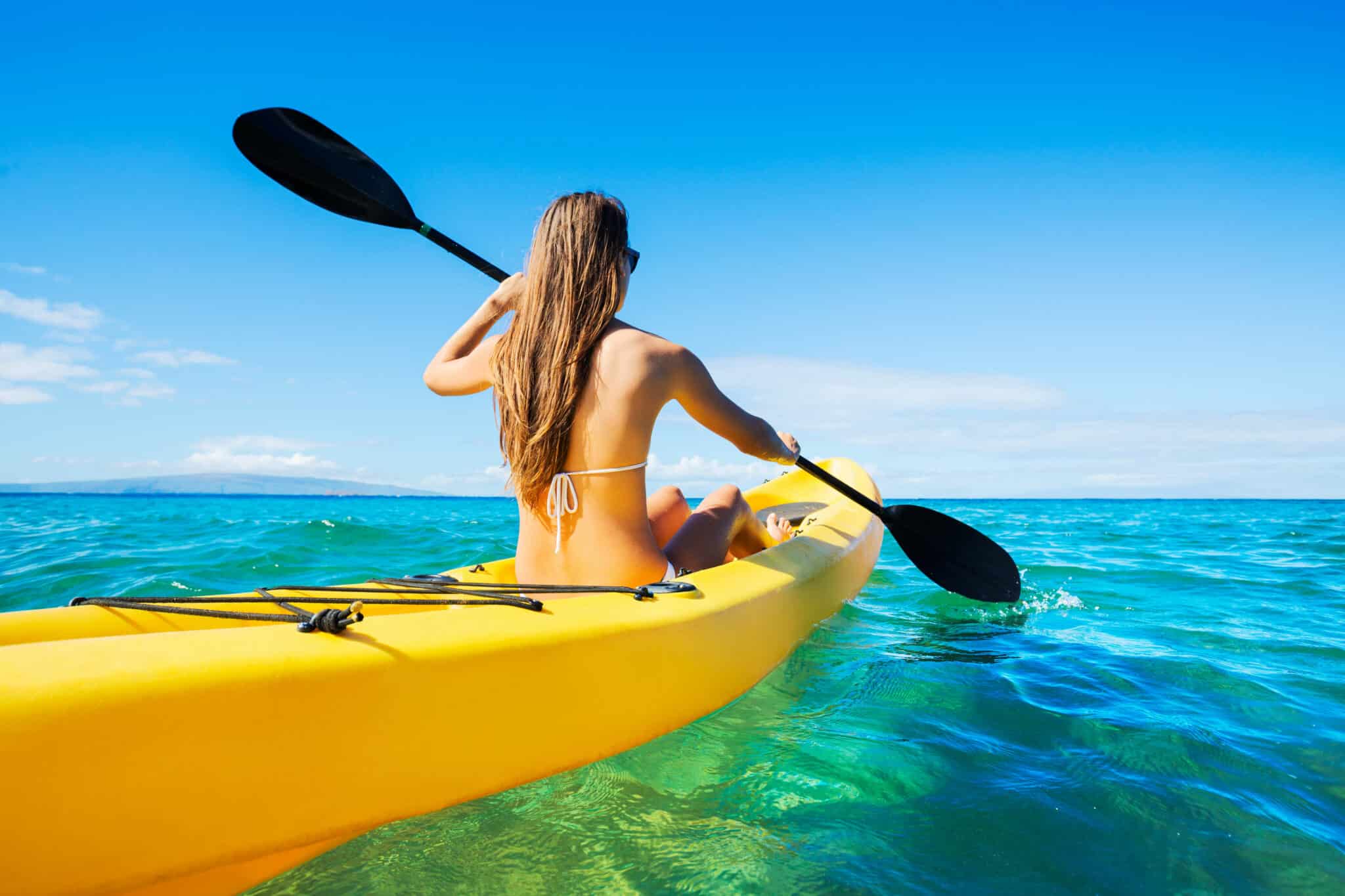 woman paddling on a yellow kayak